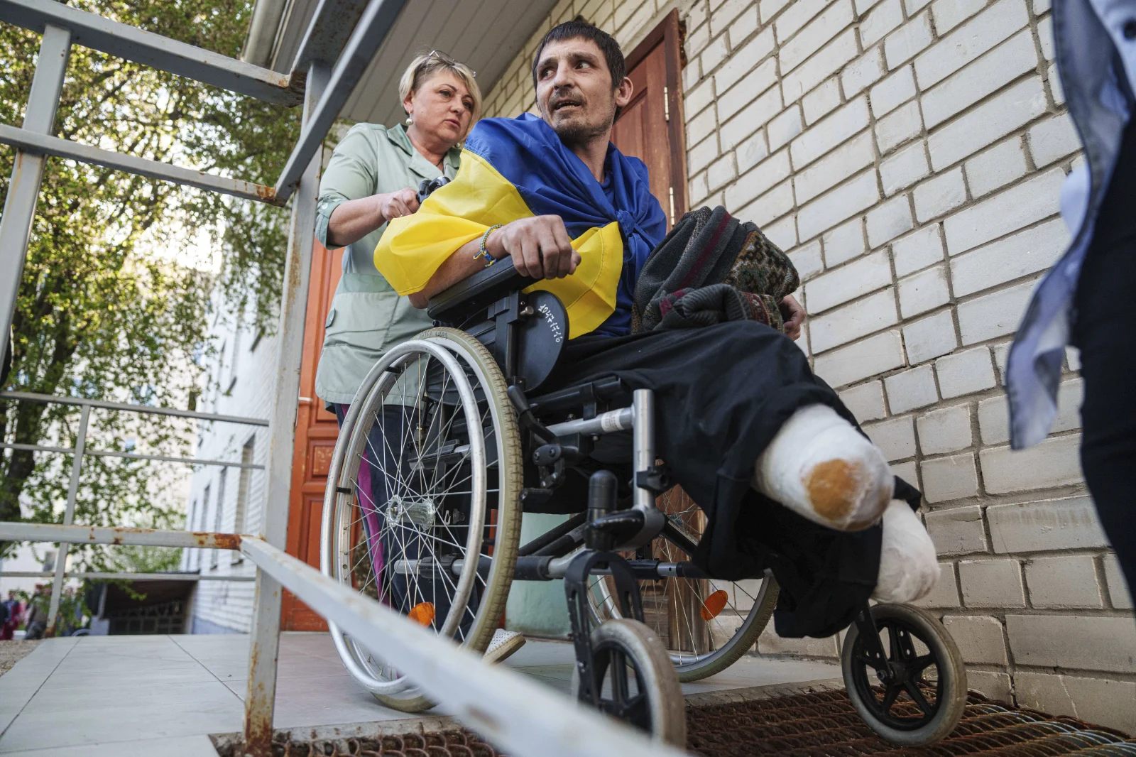 Медичний працівник на інвалідному візку перевозить пораненого українського військового з санітарної машини після повернення з полону під час обміну військовополоненими в Україні в суботу, квітня. 19 січня 2025 року